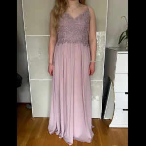 Rosa klänning med spets från Mascara London💗 - En superfin rosa långklänning i storlek 40.💗🤗Klänningen är liten i storleken. Använd en gång. Ordinarie pris ca 1500kr. Frakt tillkommer.💗