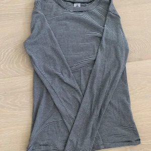 Randig långärmad tröja - En randig långärmad tröja som är stretchig och tajt i storlek xs. Den är köpt ingen butik i Paris och aldrig blivit använd.