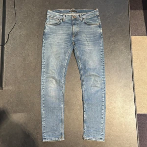 Nudie Jeans - Säljer ett par ljusblå jeans från Nudie Jeans i storlek 31/32. Modellen är Lean Dean och har en slim passform. Perfekta till vardags för en clean och stilren look.