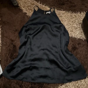 Svart satin linne med smala axelband - Säljer min svarta satin linne med smala axelband som är i storlek L men passar folk i storlek S-M samt har den bara använts 1-2 gånger och är därför i väldigt bra skick.  Säljer för 60kr