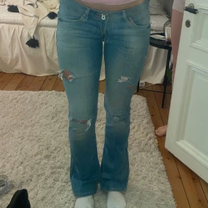 Lågmidjade bootcutjeans från Lee - Säljer ett par jättefina lågmidjade blå bootcut jeans med slitningar på låren och knäna💕. Jeansen har normal passform och klassisk femficksdesign. 🫶 Innerbenslängden är 80 cm och midjemåttet är 36 cm rakt över⭐️Har någon defekt som knapts snyns 🫶SKRIV OM NI HAR FRÅGOR ELLER VILL HA FLER BILDER ! 💕🫶