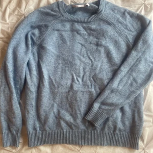 Ljusblå stickad tröja från ONLY - Mysig ljusblå stickad tröja från ONLY med rund halsringning och ribbade muddar vid ärmslut och nederkant. Perfekt för lager-på-lager och enkel att matcha med jeans eller kjol. Tröjan är väl använd så den har lite små anmärkningar 
