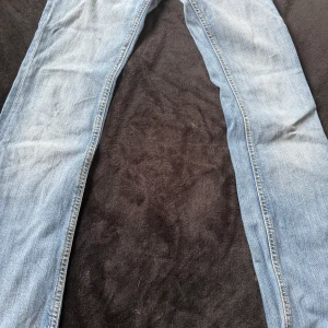 Ljusblå bootcut jeans  - Säljer ett par ljusblå lågmidjade bootcut jeans med coola bakfickor och guldfärgade sömmar. Super snygga!! Obs finns 3 små fläckar kan skickas bild på super små och syns inte storlek 25 så xs typ 