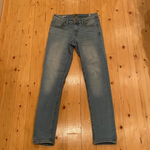 Ljusblå jeans från Jack & Jones 158 - Säljer ett par ljusblå jeans från Jack & Jones i storlek 158. Klassisk femficksmodell med snygga detaljer på bakfickorna och bruna sömmar. Jeansen har rak passform och är tillverkade i mjukt denimtyg. Perfekt för dig som gillar enkel och stilren look. Priset kan diskuteras