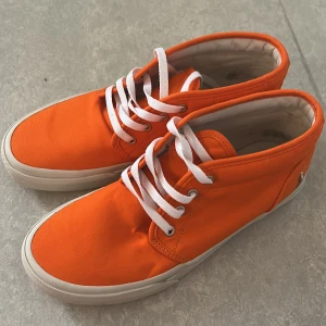 Orange sneakers från Polo Ralph Lauren - Fräscha orange sneakers från Polo Ralph Lauren med vit sula och vita snören. Skorna har en klassisk rund tå och är tillverkade i bomullstyg. Ikonisk Polo-logga broderad på sidan och tryckt på innersulan. Perfekt för dig som vill sticka ut med färg. Storlek 41 & pris går att diskuteras vid snabb affär