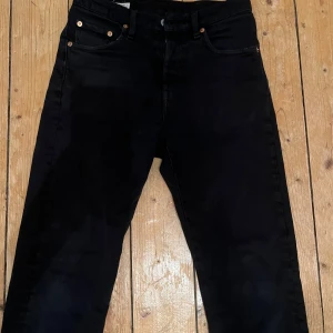 Svarta Levi's 501 Premium jeans - Svarta Levi's 501 Premium jeans med klassisk rak passform och fem fickor. Jeansen har en snygg svart ton och är tillverkade i slitstarkt bomullsmaterial. Perfekt för dig som gillar tidlös stil och vill ha ett par jeans som funkar till allt.  STORLEK- W24, L28