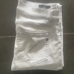 Dondup George  - Snygga ljusgrå skinny jeans från dondup i storlek 32. De har klassisk femficksdesign, smal passform och är tillverkade i mjukt jeanstyg med stretch för extra komfort. Perfekta för dig som gillar en modern och stilren look.