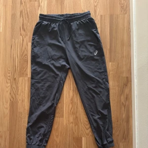  Gråa träningsbyxor från Asics - Säljer ett par gråa träningsbyxor från Asics storlek L men passar M