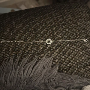 Snyggt silverarmband med hjärta - Stilrent armband i silverfärg med tunn kedja och ett glittrigt hjärta i mitten. Perfekt för dig som gillar enkla men söta detaljer. Hjärtdetaljen är omgiven av små stenar som ger extra bling. Passar till alla outfits och är lätt att matcha.