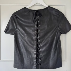 Svart topp i skinn-effekt - Så cool tröja i skinn-effekt! 🤍 Passar XS och S. Så najs till fest!!