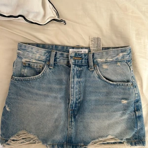 jeanskjol med slitningar  - jätte snygg jeanskjol med slitningar ifrån pull and bear som knappt är använd! säljer pga att jag har för många jeanskjolar. strl s och passar mig som brukar ha 34/36 i jeans 💕