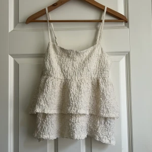 Vit/biege volangtop från Gina Tricot XS - köpte inför sommaren men hann inte använda den så helt som ny! 💕💕🥰🥰