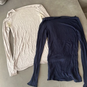 Två långärmade tröjor från intimissimi  - Säljer två stilrena långärmade tröjor från Intimissimi . Ena är ljusbeige och den andra är mörkblå, båda i mjuk och tunn bomull med lite kashmir. Passformen är slim och de har klassisk rund hals. Perfekt för lager-på-lager och chill stil. Den blå har ett hål se sista bild. Båda för 180kr