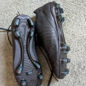 Nike Phantom GX II Club fotbollsskor svart, storlek 38 - Nike Phantom GX II Club FG/MG fotbollsskor i helsvart med subtila mönster och snörning. Storlek 38. Sonen provtestade dem en gång, annars oanvänt. 