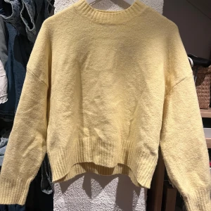 Gul stickad tröja med loose fit - Supermysig gul stickad tröja med loose passform och ribbade muddar vid ärmslut och nederkant. 