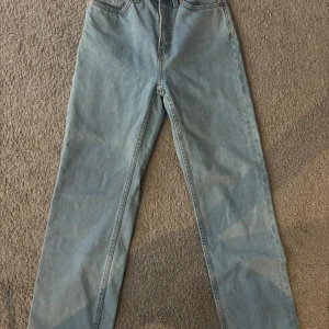 Weekday ljusblå straight jeans - Säljer ett par ljusblå jeans från Weekday, modell Voyage. De har klassisk femficksdesign, raka ben och hög midja. Jeansen är tillverkade i bomull. Har sytt upp dom så är 24/30