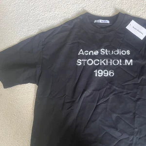 Svart Acne Studios t-shirt Stockholm M - Svart t-shirt från Acne Studios med vit text 'Acne Studios STOCKHOLM 1996' på bröstet. Skickas med tag, skriv vid någon fundering🙌