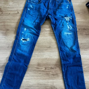 Replay Anbass slim fit jeans blå - Snygga blå Replay Anbass jeans i slim fit med slitna detaljer, knappt använda!