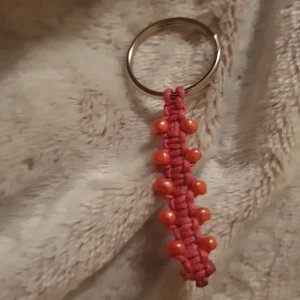 Enkel nyckelring  - En enkel handgjord nyckelring med röda pärlor, perfekt om man vill sätta lite färg på vardagen.