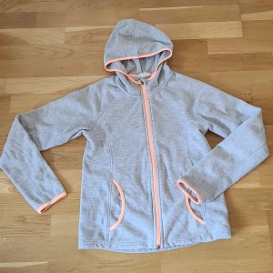 Grå fleecejacka med huva från H&M - Grå fleecejacka från H&M Sport. Köparen står för frakten 