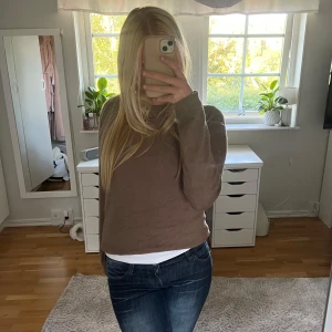 Brun stickad tröja med rund hals - Mysig brun stickad tröja med rund hals och ribbade muddar vid ärmslut och nederkant. Perfekt att slänga på sig när det är lite kyligt ute. Långärmad och har en enkel, klassisk look som funkar till allt!💞