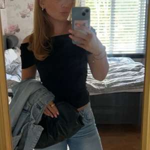 Svart offshoulder topp från Zara - Säljer en svart offshoulder topp från Zara med tight passform. Toppen är ärmlös och har en snygg croppad design som sitter perfekt över axlarna. Materialet är mjuk bomull med lite stretch, vilket gör den superbekväm och enkel att styla till jeans eller kjol.