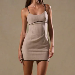 Beige kort klänning med spetsdetaljer - Snygg beige kortklänning med smala axelband och diskreta spetsdetaljer längs kanterna. Figurnära passform och enkel, stilren design som ger en clean look. Perfekt för dig som gillar minimalistisk stil med en touch av elegans.