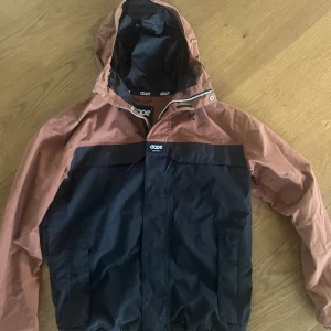 Svart och brun jacka från Dope - Riktigt snygg Dope jacka helt i nyskick. Använde den endast en skidsäsong för några år sedan och därför väldigt bra skick. Storleken är small men passar även medium.