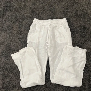 Vita linnebyxor med snörning - Snygga vita linnebyxor som är lowwaist och har fickor både fram och bak. Nästan aldrig använda. Är från Chelsea.