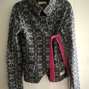 Mönstrad Odd Molly kofta med storleken  1 (S 36). Mer bilder finns på Vinted  - Unik kofta från Odd Molly i blått och vitt med snyggt geometriskt mönster. Långärmad modell med rosa rosetter och knytband som cool detalj. Koftan är tillverkad i mjuk ullblandning och har en feminin, normal passform. Perfekt för dig som gillar statement-plagg!