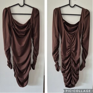 Brun långärmad draperad klänning - Snygg brun klänning med långa ärmar och draperad design både fram och bak. Klänningen har en djup urringning och rynkade detaljer längs hela längden för en cool och trendig look. Perfekt för dig som gillar att sticka ut med stil.