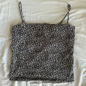 leopardmönstrat linne - Snyggt leopardmönstrat linne med smala axelband från Gina Tricot. Perfekt till vardags eller en utekväll. Har bara använts ett fåtal gånger och har inga defekter. Den är lite kortare i modellen och har dubbelt tyg över bysten så man slipper bära bh! 🤎