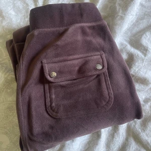 Bruna mjukisbyxor Juicy Couture XS - Mysiga bruna mjukisbyxor från Juicy Couture i velour med bred resår i midjan, snörning och fickor med tryckknappar bak. Klassisk broderad JC-logga framtill. Jättesköna men får aldrig nån användning för dom. köpte för 1200kr och har använt dom cirka 4 gånger så säljer för 950kr