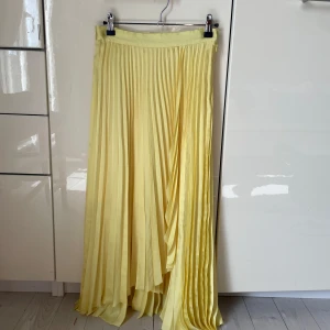 Ljuvlig kjol & Other Stories - Superfin ljusgul plisserad långkjol från & Other Stories Paris Atelier. Kjolen är i glansig polyester med snyggt fall. Jag älskar denna kjol men den passar tyvärr inte längre. 