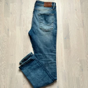 Jeans från Jack & Jones - Snygga blå jeans från Jack & Jones med lätta slitningar på framsidan. Feta jenas i mycket bra skick!!!! Storlek 31 32 skriv för mer frågor