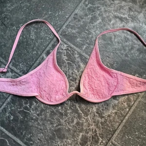 Rosa bikiniöverdel - Supersöt rosa bikiniöverdel med volangig struktur och tunna axelband. Bikinin är väldigt fin med vågig yta och triangelformade kupor.🩷