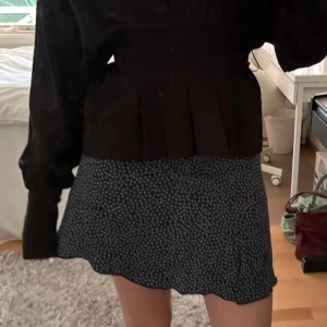 Mörkblå blommig kortkjol - Supersöt mörkblå kortkjol med blommönster. Perfekt till sommaren!