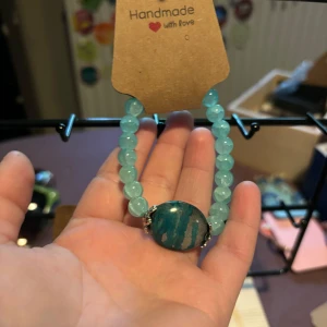 Handgjort blått pärlarmband - Unikt armband med ljusblå runda pärlor och en stor, oval blå sten i mitten med marmorliknande mönster. Perfekt accessoar för att ge din outfit en färgklick. Elastiskt band för enkel användning.