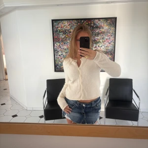 Krämvit kofta från Gina  - Supermjuk och lite croppad kofta i krämvit färg från Gina tricot. Koftan har långa ärmar, rund halsringning och knäpps med små knappar. Säljer då den inte kommer till användning💕