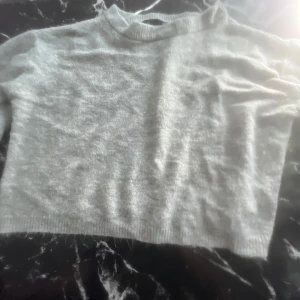 Ljusgrå stickad tröja från lager157 - Mysig ljusgrå stickad tröja från lager157 med rund halsringning och ribbade muddar. Tröjan har en enkel och clean design, perfekt att slänga på sig över ett linne eller t-shirt. Passar dig som gillar en basic och stilren look. Tröjan är andvänd en gång. Köpt för 150kr 