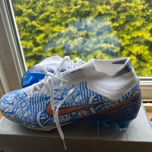 Nike Air Zoom Mercurial Superfly 9 Elite FG CR7 - Säljes: Nike Air Zoom Mercurial Superfly 9 Elite FG CR7 – Strl 44  Grymma fotbollsskor från Nike – Air Zoom Mercurial Superfly 9 Elite FG CR7. Designade i samarbete med Cristiano Ronaldo, med en unik vit/blå/guldig färgkombination och avancerad teknik för max prestanda på planen.