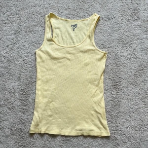 Ljusgult linne - Gult linne som går nedanför naveln. Så fin ”butter yellow” färg. Finns en liten missfärgning som jag försökte få med på sista bilden, kameran vill dock inte fånga upp det så bra. Annars bra skick! Passar både s och m