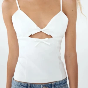 Topp  - Vit topp med rosetter från Zara. Korsettliknande, har en dragkedja på ryggen.