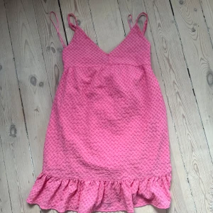 Rosa kortklänning med volangkant - Supersöt rosa kortklänning från Gina Tricot. Oanvänd!!