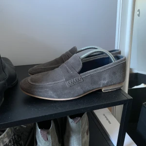 Loafers - Säljer dessa fräscha loafers i en grå/brun/grön färg. Fint använt skick, inga större skador. Storlek 44, passar även 43. 300kr! 