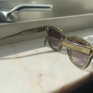 Gröna fyrkantiga solglasögon - Snygga solglasögon med transparent grönt båge och fyrkantig form. Glasen är bruna med en lätt toning. Ramen är i plast och har coola detaljer vid gångjärnen. Perfekta för att lyfta din stil i solen.