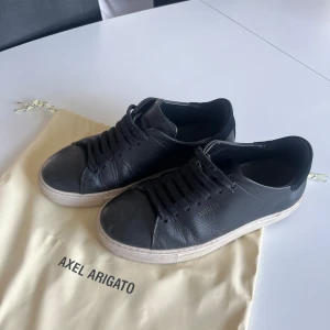 Svarta Axel Arigato sneakers - Säljer mina svarta Arigatos med snörning och vit sula i storlek 37. Små tecken på användning men i väldigt bra skick!! 