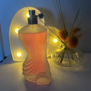 Real time kindlooks - en kvinnlig torso i frostat glas med ljusrosa innehåll. Flaskan har en silverfärgad spraykork med en liten stjärna 