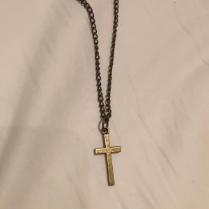 Kedjehalsband med kors i guldton - Snyggt halsband med en klassisk korsberlock i guldtonad metall. Kedjan är mörkare och har en cool, vintage!! Så bra skick också! :)
