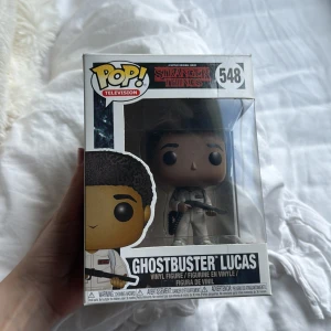 Ghostbuster Lucas (Stranger Things #548) - Cool Funko Pop! figur av Lucas från Stranger Things, utklädd till Ghostbuster. Perfekt för fans av serien och samlare som vill ha något unikt på hyllan. Kommer i originalförpackning och är en del av Stranger Things-kollektionen. Pris kan diskuteras!